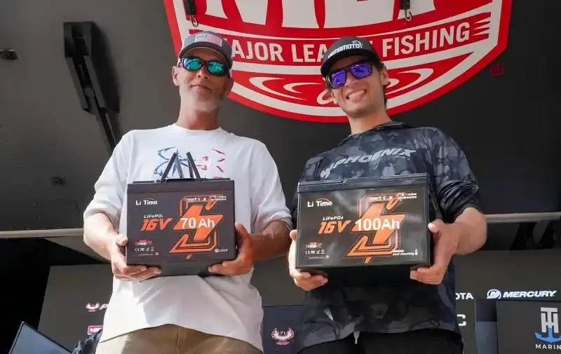 Two participants holding LiTime lithium batteries at a recreational fishing event